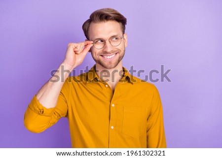 Portrait of cheerful person hand touch glasses toothy smile look empty space isolated on purple color background