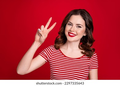 Portrait of cheerful positive cute girlfriend wear trendy clothes demonstrate v-sing good mood isolated on red color background
