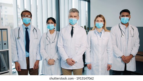 Portrait Of Cheerful Positive Multi-ethnic Different Healthcare Professional Doctors And Physicians In Medical Masks Stand In Hospital Clapping Hands And Applauding, Covid Quarantine Concept