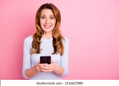 Portrait of cheerful positive woman use her cellphone read incredible feednews feel fun wear white  pullover isolated over pink color background