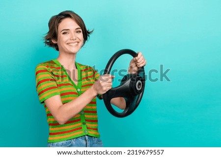 Portrait of cheerful pretty girl toothy smile hands hold wheel empty space isolated on teal color background