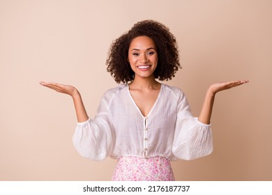 Portrait of cheerful pretty lady arms palms hold show empty space vs scales isolated on beige color background - Shutterstock ID 2176187737