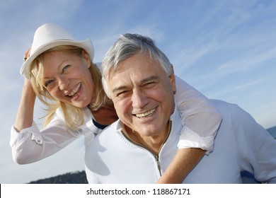 Portrait Of Cheerful Senior Couple Having Fun At The Beach