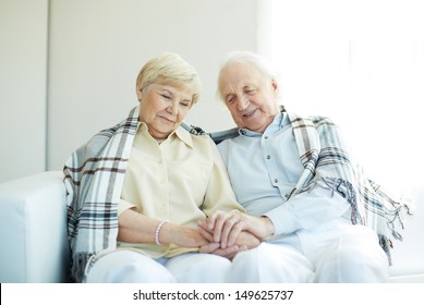 Portrait of cheerful senior couple sitting at home