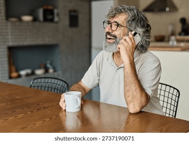 Portrait of a cheerful senior elderly man talking on phone at home