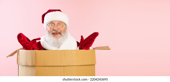 Portrait Of Cheerful Senior Man, Santa Claus Sitting Inside Cardboard Box. Happy Holidays. Delivery Service. Concept Of Gifts, Shopping, Emotions, Facial Expression. Unpacking Box.