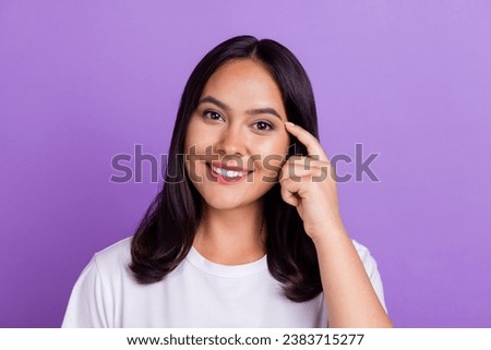 Portrait of cheerful smart lady pointing her finger touching temple thinking about incredible idea isolated on purple color background