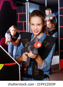 Portrait Of Cheerful Smiling Teenager Girl With Laser Gun Having Fun With Her Family On Lasertag Arena