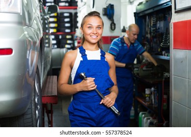 portrait of cheerful smiling young woman in protective workwear working as auto mechanic in workshop
 - Powered by Shutterstock