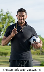 Portrait Of Cheerful Soccer Coach Holding A Ball