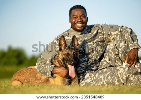 Portrait of cheerful soldier and trained military dog.