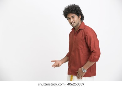 Portrait of cheerful South Indian man greeting on white background.