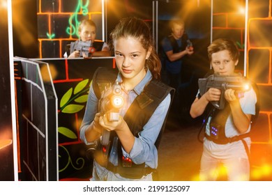 Portrait Of Cheerful Teenager Girl With Laser Gun Having Fun With Her Family On Lasertag Arena