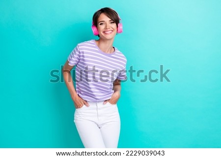Portrait of cheerful toothy beaming positive girl with bob hairdo wear striped t-shirt arms in pockets isolated on teal color background