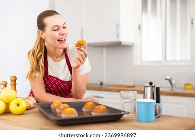 Portrait of cheerful woman in apron eating - Powered by Shutterstock