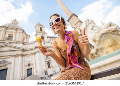 Portrait of a cheerful woman eating ice cream in cone while visiting famous Navona square near fountain in Rome. Concept of happy summer vacations, traveling famous italian landmarks - Shutterstock ID 2160141917