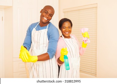 Portrait Of Cheerful Young African Couple Cleaning Bedroom