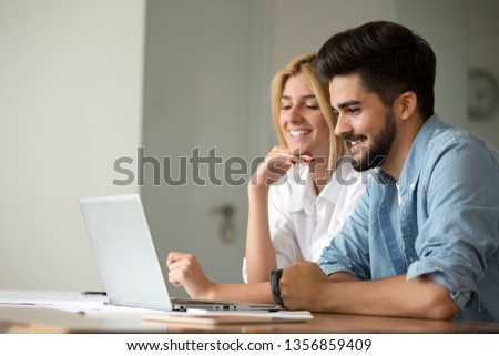Portrait of a cheerful young couple calculating their bills