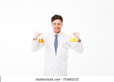 Portrait Of A Cheerful Young Male Scientist Dressed In Uniform Showing Test-tubes Isolated Over White Background