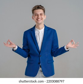 Portrait Of A Cheerful Young Man Standing And Showing Ok Gesture With Two Hands Isolated Over Grey Background. Waist Up Of Young Man In Blue Jacket