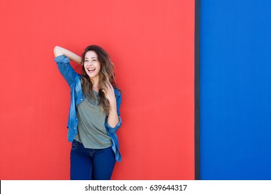 Portrait Of Cheerful Young Woman Against Red Wall