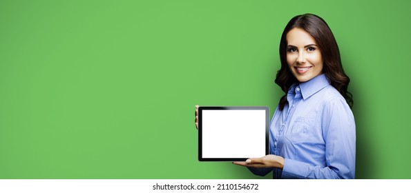 Portrait Of Cheerfully Smiling Brunette Businesswoman Showing Mock Up Blank Tablet Pc, Ipad Touchpad, With Copy Space Area For Text, On Green Color Background. Confident Young Business Woman At Studio