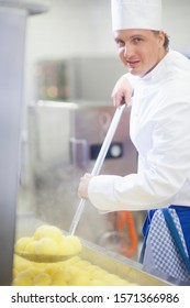 Portrait Of Chef In Kitchen Holding Ladle