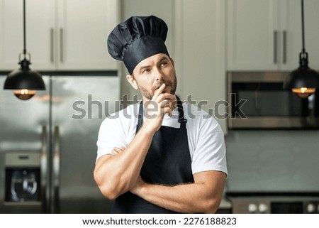 Portrait of chef man in a chef cap in the kitchen. Man wearing apron and chefs uniform and chefs hat. Character kitchener, chef for advertising.