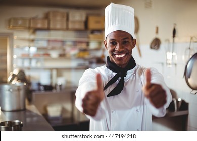 Portrait of chef standing in kitchen showing thumbs up - Powered by Shutterstock