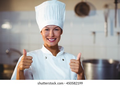 Portrait of chef standing in kitchen showing thumbs up - Powered by Shutterstock