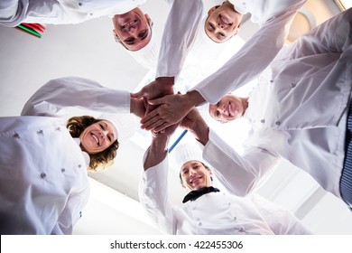 Portrait Of Chefs Team Putting Hands Together And Cheering In A Commercial Kitchen