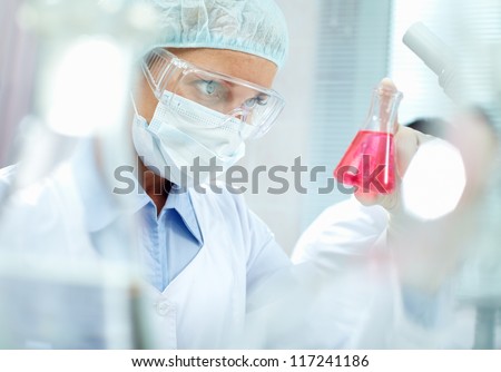 Portrait of a chemist holding a tube with liquid