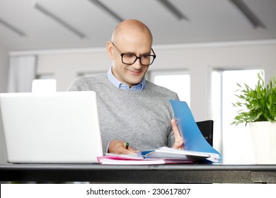 Portrait Of Chief Financial Officer Analyzing Data On Laptop, While Sitting At Office.  Business People.