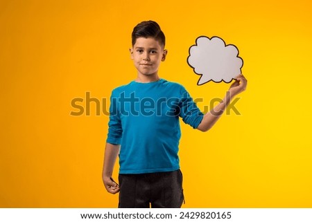 Portrait of child boy holding think cloud bubble card. Dreaming and idea concept