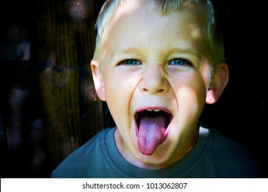 Portrait Of Child Boy Showing Tongue