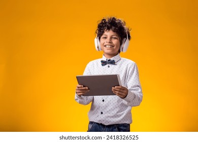 Portrait of child boy using digital tablet and headphones and playing video game. Leisure and gadget addiction concept. - Powered by Shutterstock