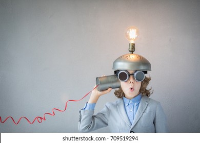 Portrait of child in classroom. Child with toy virtual reality headset in class. Funny kid with light bulb. Communication, idea and innovation technology concept. Back to school