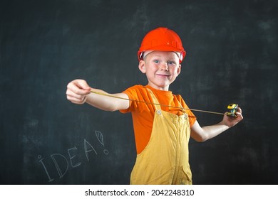 Portrait of child dressed as builder with ruller in hands. Little boy wearing hard ptotect helmet. Little builder in hard hat. Back to school and profession concept.