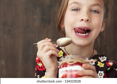 Portrait Of A Child Eating Sweet Homemade Dessert With Berries