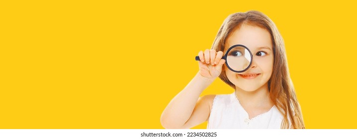 Portrait of child looking through magnifying glass isolated on yellow background - Shutterstock ID 2234502825