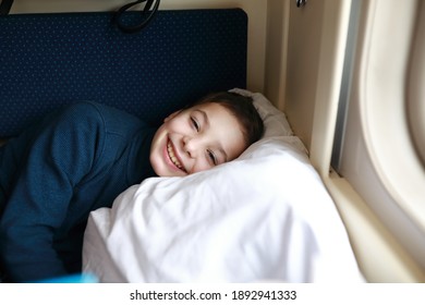Portrait of child lying in train compartment - Shutterstock ID 1892941333