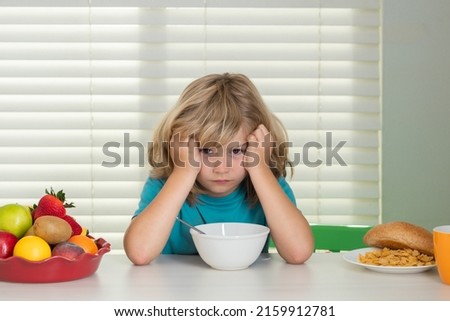 Portrait of child with no appetite. Concept of loss of appetite. Healthy nutrition for children. Cute boy enjoy eating for morning breakfast with appetite. Hungry child eat tasty fruits and vegetables