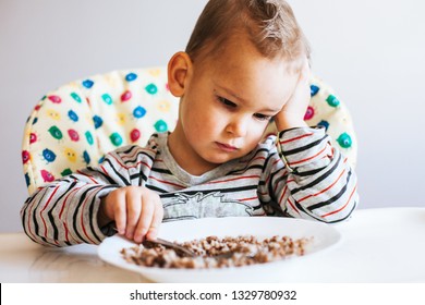 Portrait Of Child With No Appetite In Front Of The Meal
