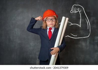 Portrait of child in red safety helmet and in business suit and glasses. Little businessman shows muscle. School smart kid has idea. Pupil engineer. Success, creative and innovation business concept. - Powered by Shutterstock