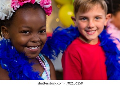 Portrait of children with feather boa during birthday party - Powered by Shutterstock