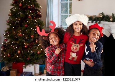 Portrait Of Children Wearing Festive Jumpers And Hats Celebrating Christmas At Home Together - Powered by Shutterstock