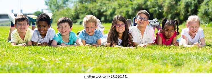 Portrait of children who are posing lying in the park. High quality photo