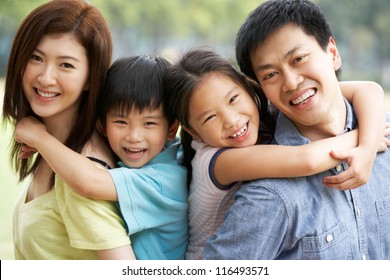 Portrait Of Chinese Family Relaxing In Park Together
