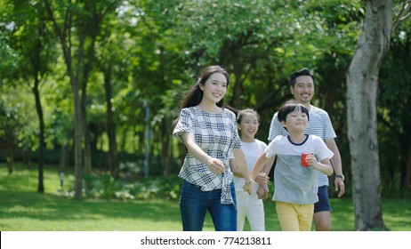 Portrait Of Chinese Parents & Kids Walking Outdoors & Laughing