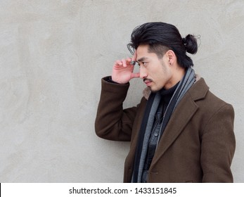 Portrait Of Chinese Young Mustached Man Put His Hand On His Forehead With Gray Wall Background, Thinking, Side View.